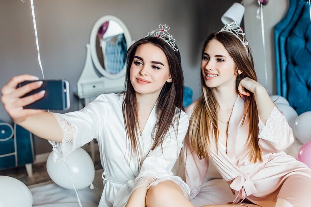 Porträt von zwei Frauen machen Selfie im Schlafzimmer, haben einen guten Junggesellinnenabschied