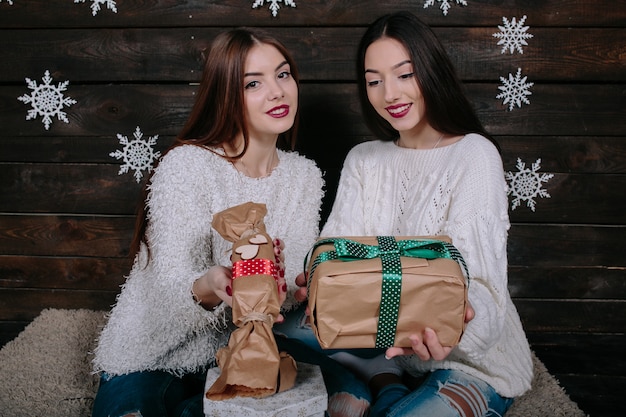 Porträt von zwei hübschen jungen frauen mit weihnachtsgeschenken