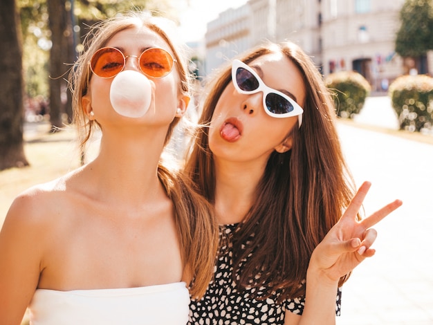 Porträt von zwei jungen schönen lächelnden Hippie-Mädchen in der modischen Sommerkleidung