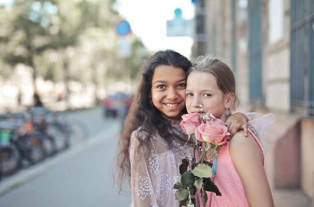 Porträt von zwei kleinen Mädchen auf der Straße mit Rosen