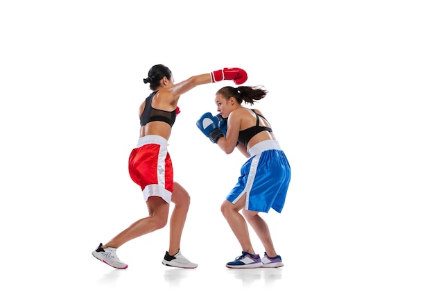 Porträt von zwei sportlichen Frauen, die professionelle Boxer trainieren, isoliert auf weißem Studiohintergrund