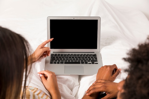 Kostenloses Foto porträt von zwischen verschiedenen rassen paaren unter verwendung des laptops zusammen