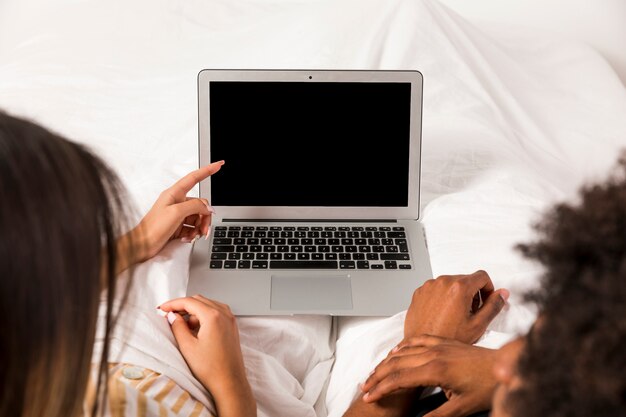 Porträt von zwischen verschiedenen Rassen Paaren unter Verwendung des Laptops zusammen