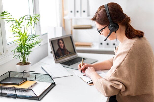 Porträtfrau bei der Arbeit, die Videoanruf auf Laptop hat