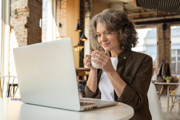 Porträtfrau mit Laptop arbeiten