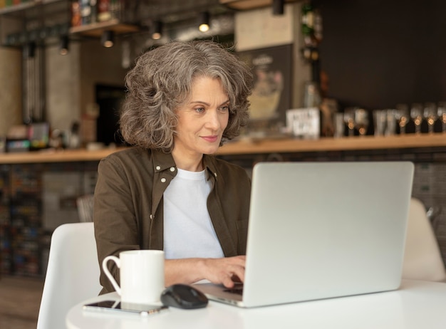 Porträtfrau mit Laptop arbeiten