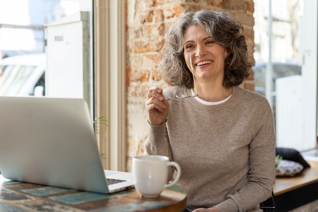 Porträtfrau mit Laptop arbeiten