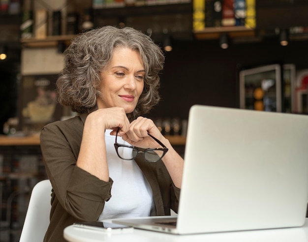 Porträtfrau mit Laptop arbeiten