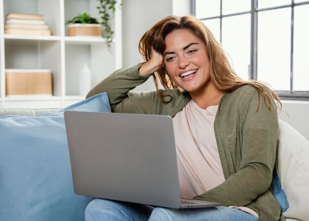 Porträtfrau zu Hause mit Laptop