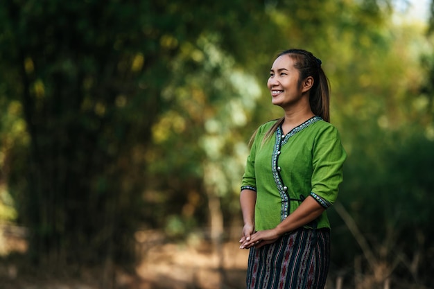 Portrait Asiatische junge hübsche Frau, die schöne Tücher trägt, steht und lächelt, während sie sich in der Landschaft Thailands entspannt, Kopierraum