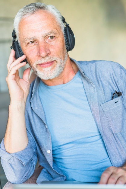 Portrait der älteren männlichen hörenden Musik auf Kopfhörer