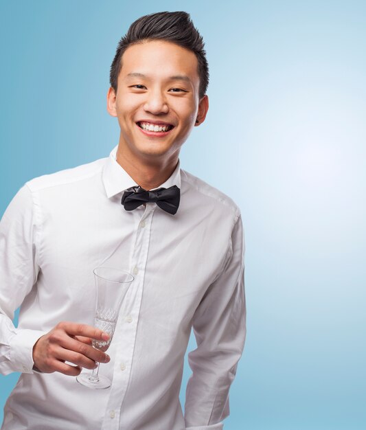 Portrait der eleganten jungen asiatischen Mann mit einem Glas