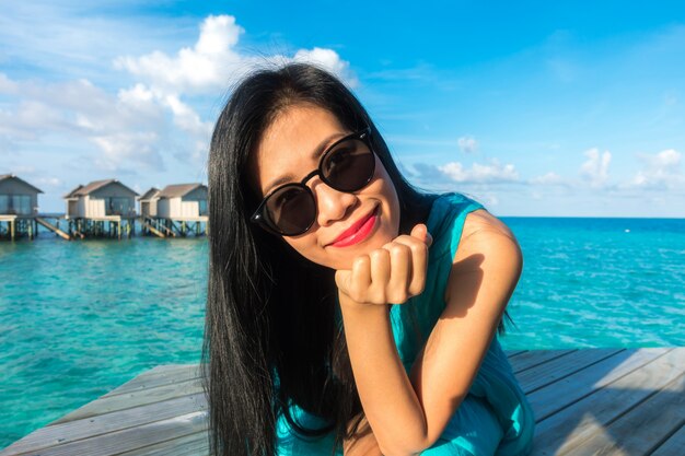 Portrait der glücklichen jungen Frau auf schöne Wasser-Villa auf Malediven Insel. Reisen und Urlaub. Außenaufnahme