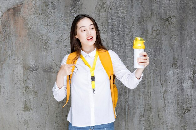 Portrait der jungen Frau, die Wasserflasche hält. Foto in hoher Qualität