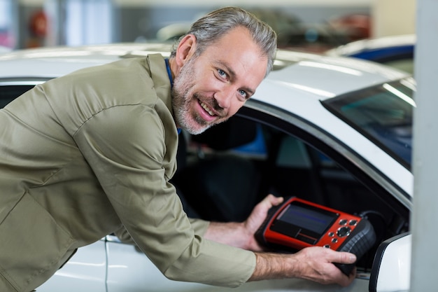 Kostenloses Foto portrait der mechaniker, der ein diagnosegerät