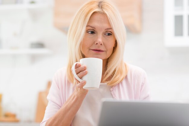 Portrait der schönen Frau den Laptop betrachtend