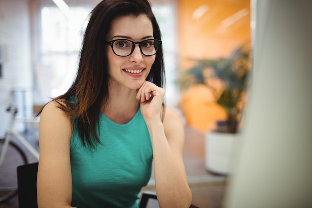 Kostenloses Foto portrait der schönen frau exekutive sitzen an ihrem schreibtisch