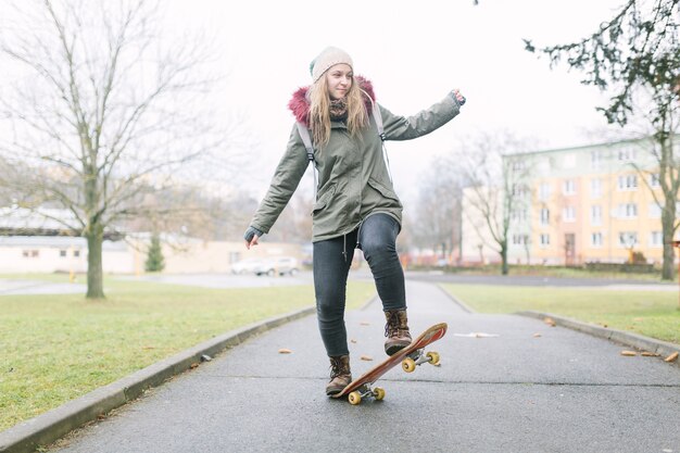 Portrait des weiblichen Skateboardfahrers auf Gehweg