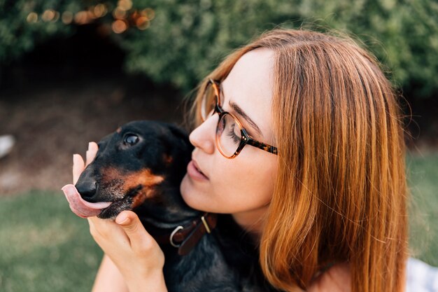 Portrait einer Frau mit ihrem Hund, der heraus Zunge haftet