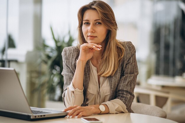 Portrait einer Geschäftsfrau, die an Laptop arbeitet