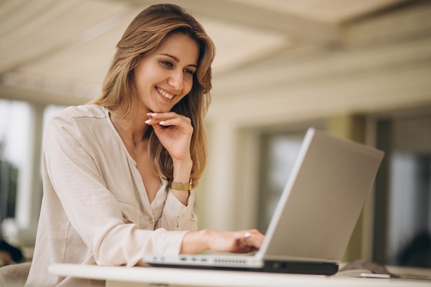 Portrait einer Geschäftsfrau, die an Laptop arbeitet