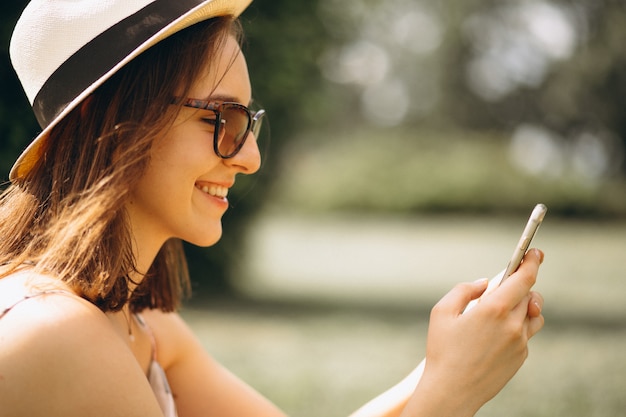 Portrait einer glücklichen Frau im Hut, der am Telefon spricht