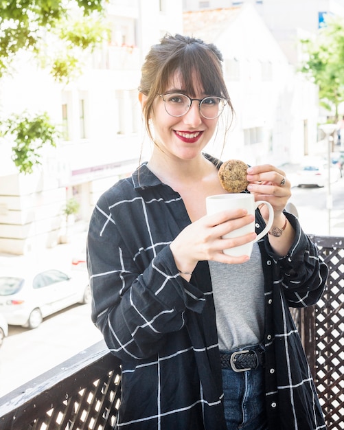 Portrait einer glücklichen Frau mit Tasse Tee und Plätzchen