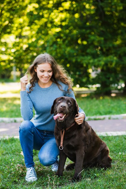 Portrait einer glücklichen Frau und ihres Hundes im Garten