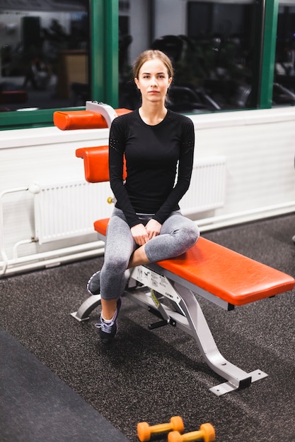 Kostenloses Foto portrait einer jungen frau, die in der gymnastik sitzt