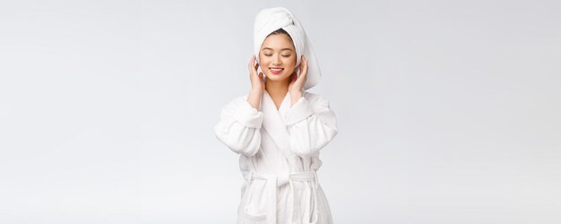 Portrait einer jungen glücklichen asiatischen Dame in bathrobeIsolated im weißen Hintergrund