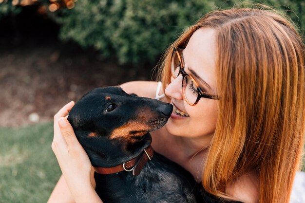 Portrait einer schönen jungen Frau, die mit ihrem Hund genießt