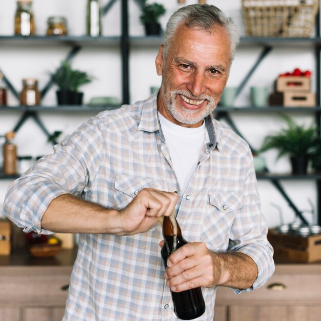 Portrait eines älteren Mannes, der die Bierflasche öffnet