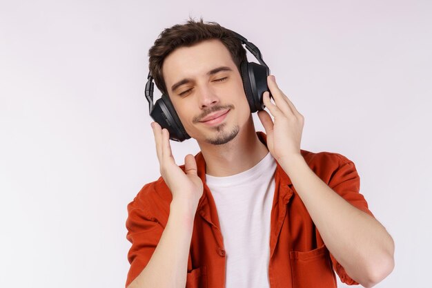Portrait eines glücklichen jungen Mannes mit Kopfhörern und genießen Sie Musik auf weißem Hintergrund