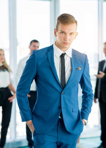 Portrait eines jungen Geschäftsmannes, der im Büro steht