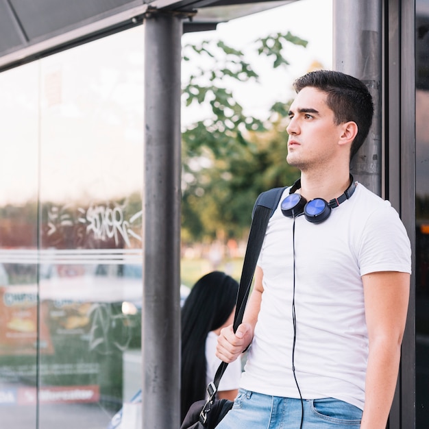 Portrait eines jungen Mannes an der Bushaltestelle