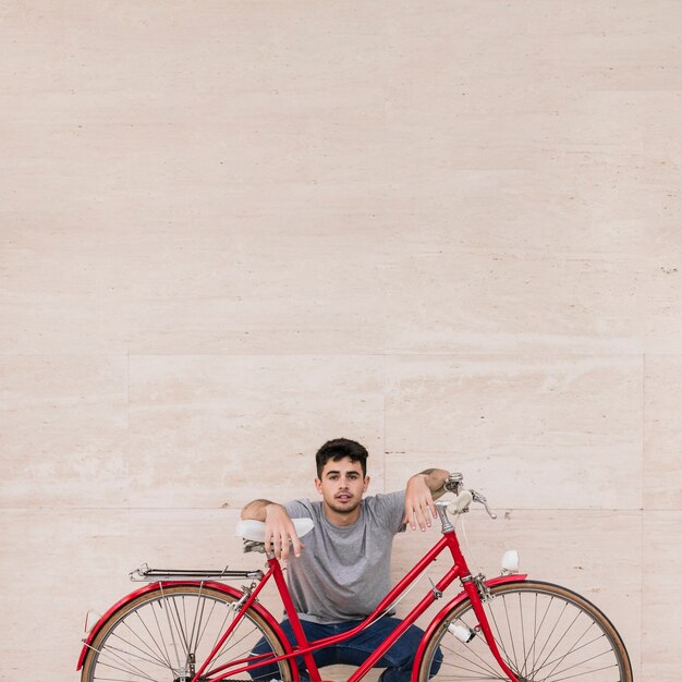 Portrait eines jungen Mannes, der hinter Fahrrad sitzt