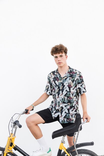 Portrait eines jungen Mannes mit Fahrrad auf weißem Hintergrund