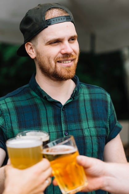 Kostenloses Foto portrait eines mannes, der bier mit seinen freunden genießt