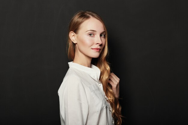 Portrait junge, schöne Frau auf schwarzem Hintergrund