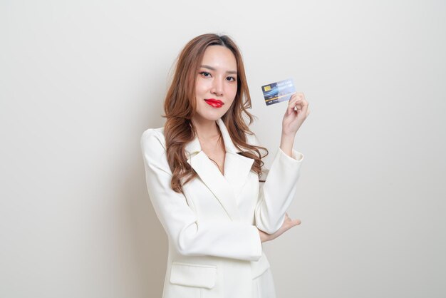 Portrait schöne asiatische frau mit kreditkarte auf weißem hintergrund