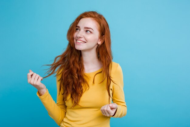 Portrait von glücklichen Ingwer rote Haare Mädchen mit Freckles lächelnd Blick in die Kamera. Pastell blauen Hintergrund. Text kopieren