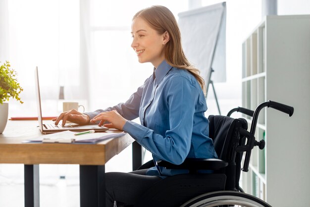 Positive erwachsene Frau, die im Büro arbeitet