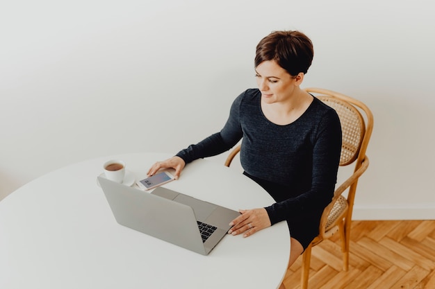 Positive Frau mit einer Tasse Tee Telearbeit