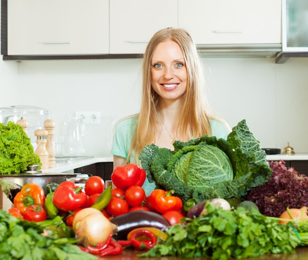 Positive Frau mit Haufen von rohem Gemüse
