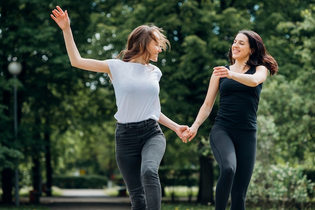 Kostenloses Foto positive freundin, die hände laufen lässt und anhält