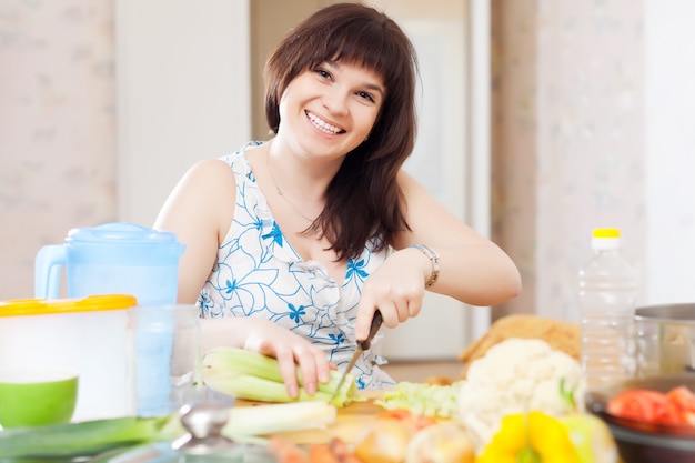 positive Hausfrau, die mit Sellerie kocht