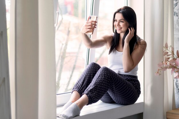 Positive junge Frau, die ein Selfie nimmt