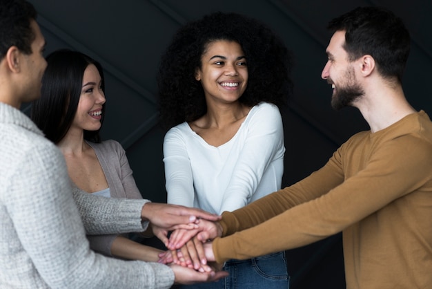 Positive junge leute, die hände berühren