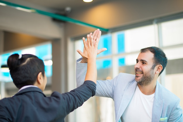 Positive lateinische und asiatische Manager mit hohem Fiving