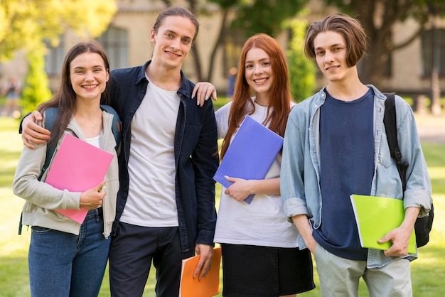 Positive Teenager, die zusammen an der Universität posieren